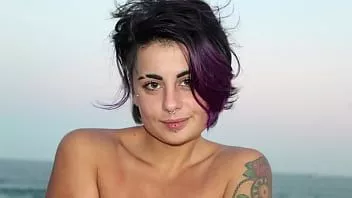 Play Beautiful tattooed woman with colored hair